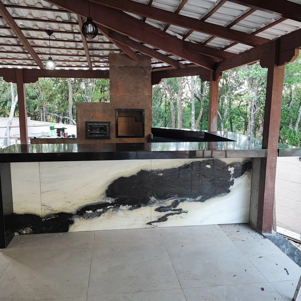 Área gourmet com bancada e churrasqueira em pedra